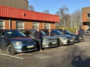 Members of the John E Wright with a new fleet of electric vehicles.